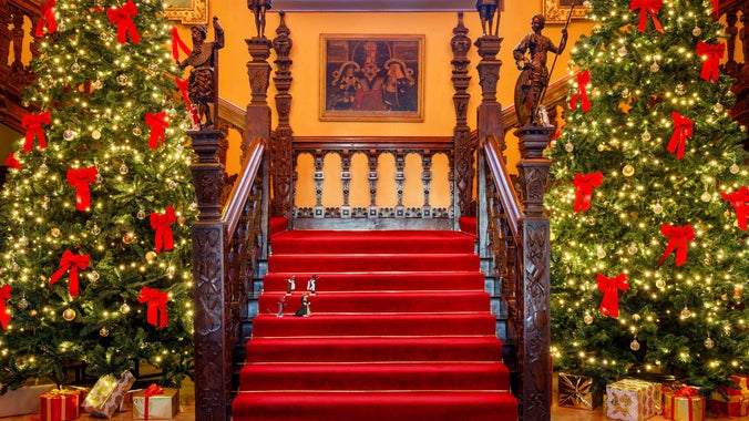 The Great Hall decorated for A Mouse's Christmas at Blickling Hall, with two Christmas trees and felt mice on the stairs Norfolk